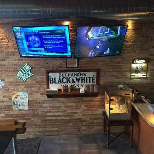 a bar with two televisions on the wall