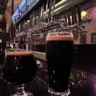 two glasses of beer on a bar