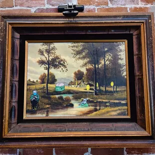 a picture of a painting hanging on a brick wall
