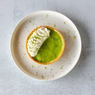 Velvety key lime pie with a crunchy graham cracker crust and whipped cream; a tangy and refreshing treat that transports you to paradise