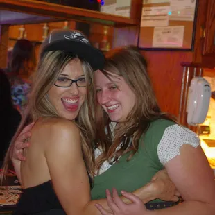 two women hugging at a bar