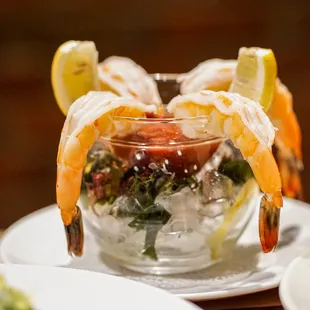 a shrimp cocktail with lemon wedges