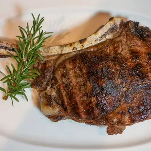 a steak with a sprig of rosemary