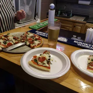 two slices of pizza on paper plates