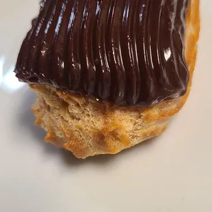 a chocolate frosted donut on a white plate