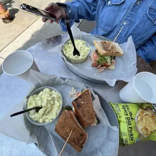 a woman eating a sandwich and chips
