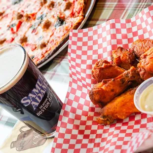 a plate of chicken wings and a beer