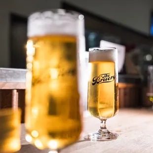 two glasses of beer on a bar