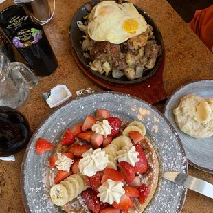 Strawberry and banana Belgian waffle, and hash brown, biscuit with steak added to it