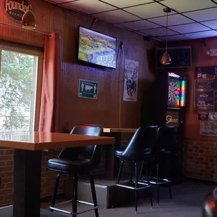 a bar with neon signs and bar stools