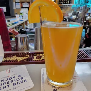 a glass of orange juice with a slice of orange