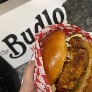 a hand holding a sandwich