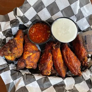 a basket of chicken wings with dipping sauce