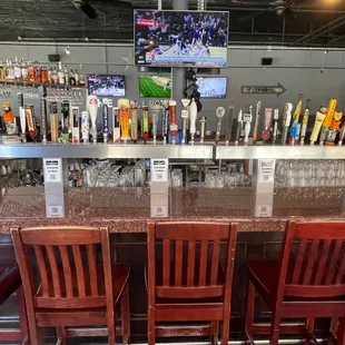 a bar with red chairs