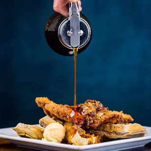 a person pouring syrup over a plate of food