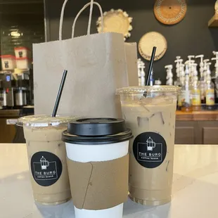 two cups of coffee and a paper bag