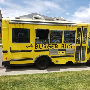 the burger bus parked on the side of the road