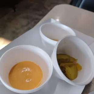 two bowls of soup and pickles