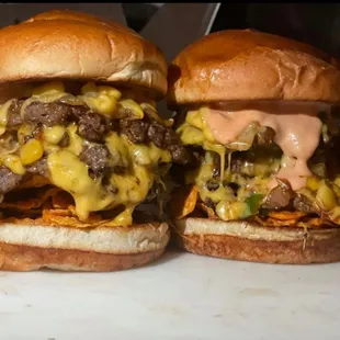 two burgers with cheese and onions