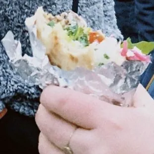 a person holding a sandwich