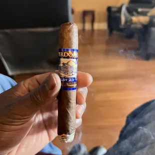 a hand holding a cigar