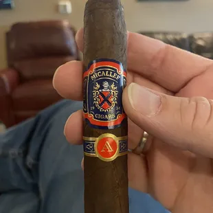 a hand holding a cigar