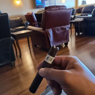 a hand holding a cigar