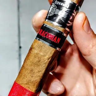 a hand holding a cigar