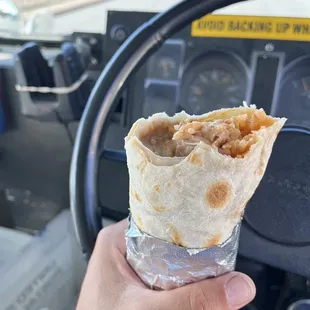 a hand holding a burrito