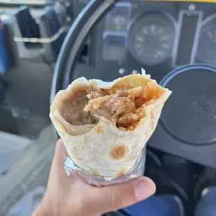 a hand holding a burrito