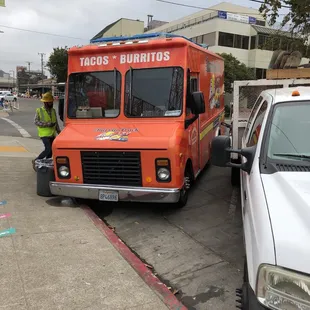an orange truck parked on the side of the road