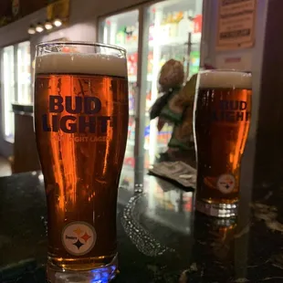 two glasses of beer on a bar