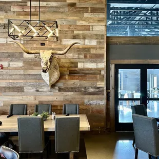 a dining room with a cow head mounted on the wall