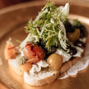 Our Burrata Bruschetta with buffalo milk mozzarella, roasted cherry tomatoes, basil, shallot, EVOO, and shaved parmesan.