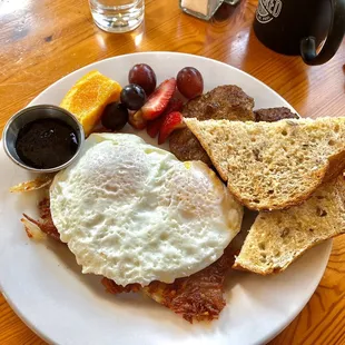 Two eggs over easy atop eXtra crispy hash browns, with sausage, toast.