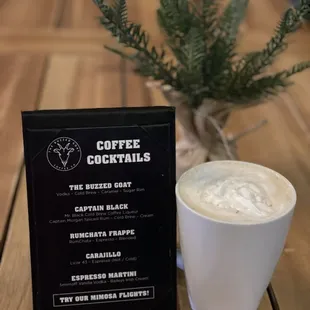 a cup of coffee next to a menu