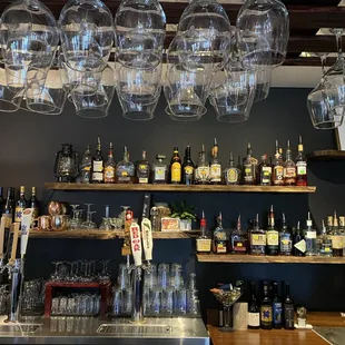 a bar with wine glasses hanging from the ceiling
