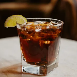 a glass of cola with a lime wedge