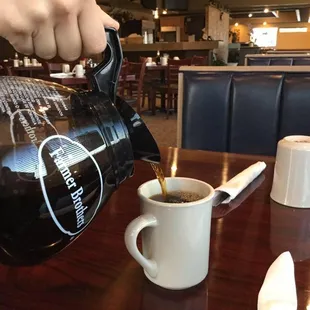 a person pouring a cup of coffee
