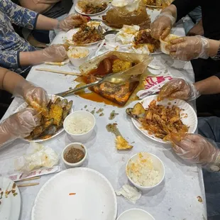 a group of people sitting around a table eating crab la habra