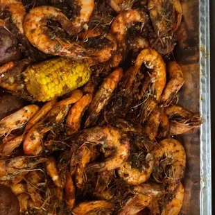 Shrimp , potatoes, sausage, corn all mixed inside a try, flick the sauce