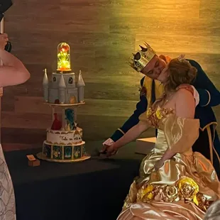 a man and a woman cutting a cake