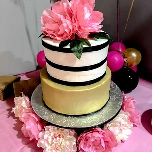 a three tiered cake with pink flowers