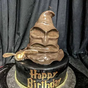 a chocolate cake with a harry potter hat on top