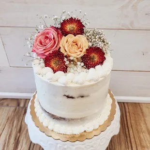 a three tiered cake with flowers on top