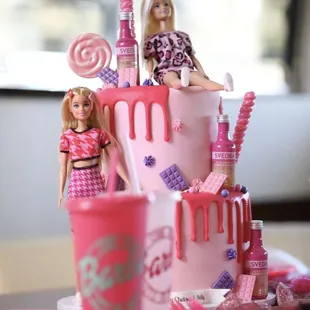 a barbie doll sitting on top of the cake