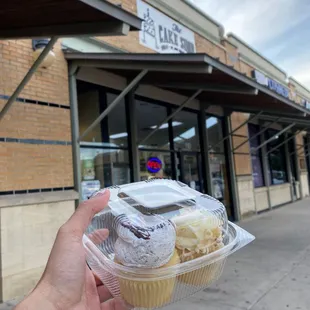 a hand holding a cupcake