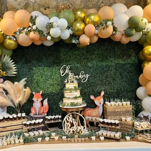 a dessert table with a cake and cupcakes
