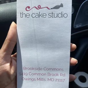 a hand holding a business card