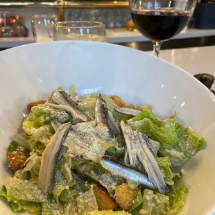 a bowl of salad and a glass of wine